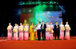 Nhà thơ Phạm Quốc Khánh tặng hoa  các nghệ sĩ trình diễn ca khúc phổ thơ.